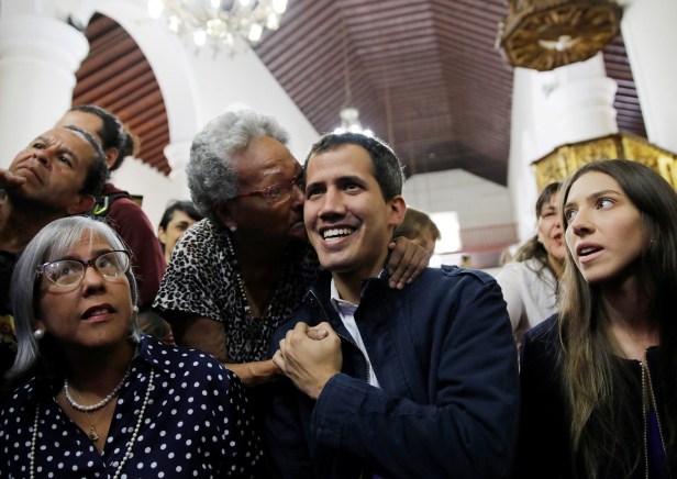 Venezuelan opposition leader and self-proclaimed interim president Juan Guaido receives a kiss as he with his wife Fabiana Rosales and mother Norka Marquez arrives to attend a holy mass in Caracas